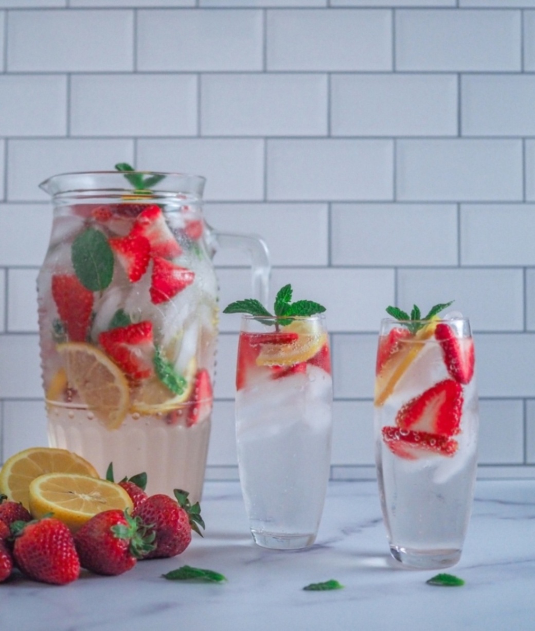 A pitcher of iced strawberry, lemon, and mint detox water