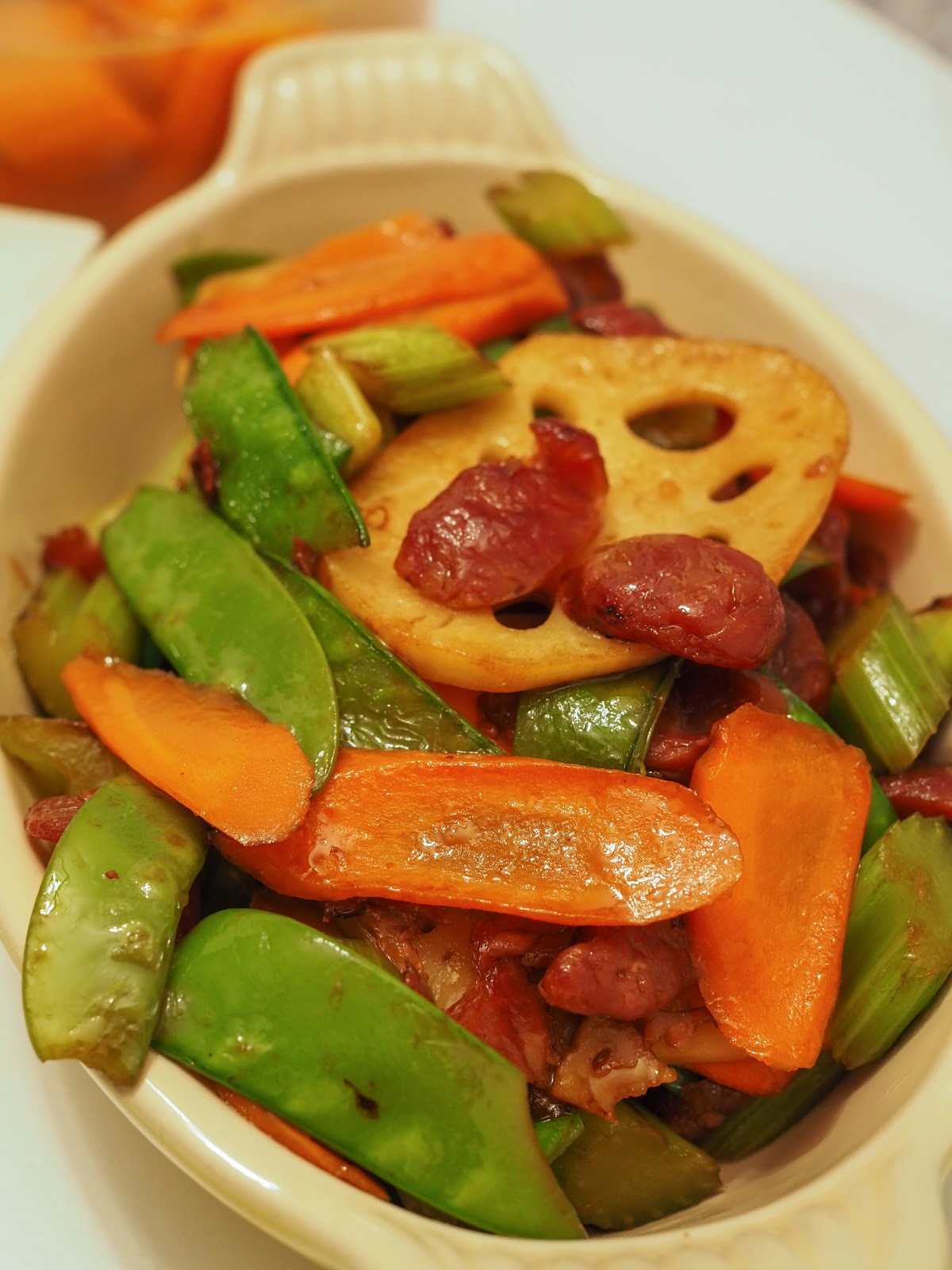 Serving dish containing wok-charred veggies and sliced chinese sausage